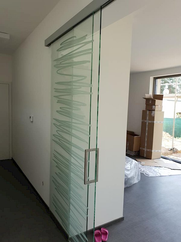 Skleněné posuvné dveře v interiéru zdobené motivem ve stylu počmárání