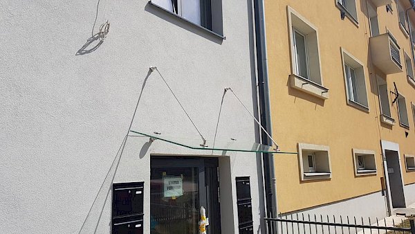 Skleněná vchodová stříška bytového domu