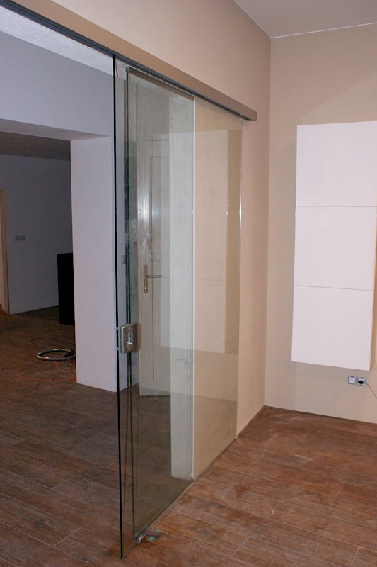 Skleněná stěna s posuvnými skleněnými dveřmi v interiéru